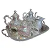 Foto de um(a) Aparelho de Chá e Café Colonial em Prata – 5 Peças Trabalhadas, da categoria de Conjuntos de café e chá. Magnífico conjunto colonial para chá e café, composto por 5 peças ricamente adornadas. Este aparelho é um exemplo clássico... Vendido no marketplace Trésors.