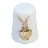 Foto de um(a) Dedal de Coleção em Porcelana – Coelhinhos e Xícara de Chá, da categoria de Outros colecionáveis. A decoração apresenta duas cenas distintas e encantadoras: de um lado, um coelhinho detalhado posando de pé; do outro, a... Vendido no marketplace Trésors.