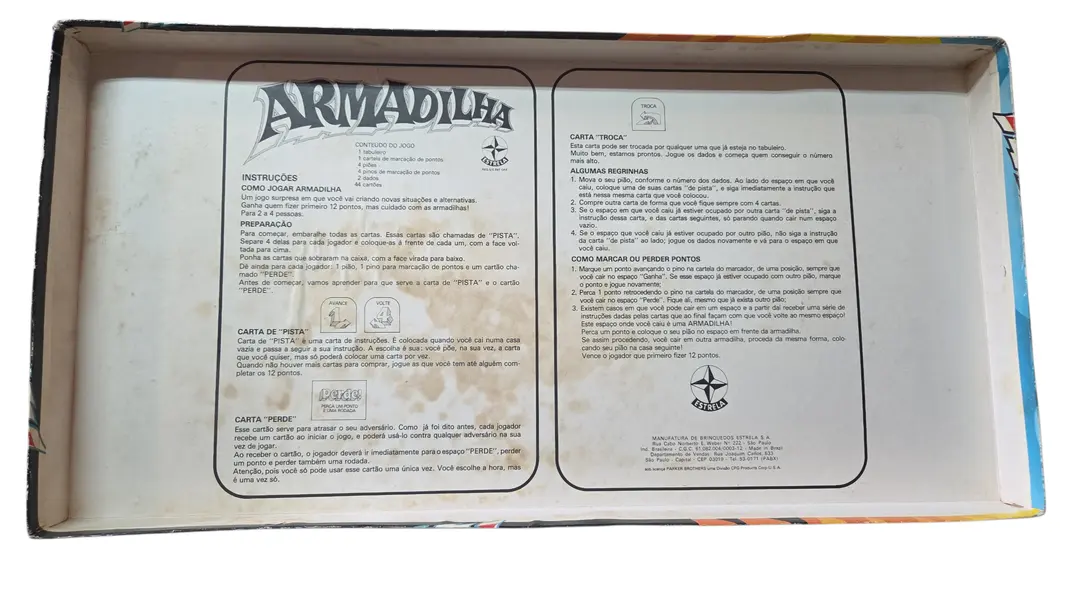 Foto de um(a) Armadilha - O Jogo de Tabuleiro (Estrela), da categoria de Jogos de tabuleiro. É um jogo de percurso e sorte onde você deve ser o primeiro a completar 12 pontos na sua trilha de marcação. A "armadilha"... Mostrado de uma perspectiva diferente. Vendido no marketplace Trésors.