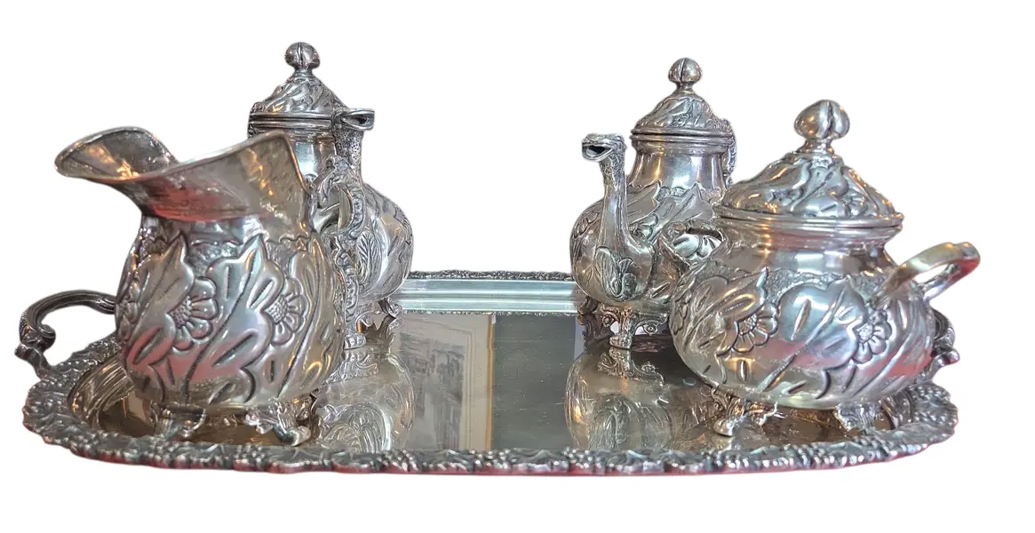 Foto de um(a) Aparelho de Chá e Café Colonial em Prata – 5 Peças Trabalhadas, da categoria de Conjuntos de café e chá. Magnífico conjunto colonial para chá e café, composto por 5 peças ricamente adornadas. Este aparelho é um exemplo clássico... Mostrado de uma perspectiva diferente. Vendido no marketplace Trésors.