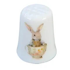Foto de um(a) Dedal de Coleção em Porcelana – Coelhinhos e Xícara de Chá, da categoria de Outros colecionáveis. A decoração apresenta duas cenas distintas e encantadoras: de um lado, um coelhinho detalhado posando de pé; do outro, a... Vendido no marketplace Trésors.