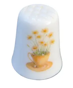 Foto de um(a) Dedal de Coleção em Porcelana – Tema Camomila e Abelha no Campo, da categoria de Outros colecionáveis. O design destaca-se pela composição harmoniosa: de um lado, um gracioso arranjo de camomilas (margaridas) brotando de uma... Vendido no marketplace Trésors.