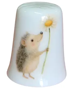 Foto de um(a) Dedal em Porcelana Decorado - Porco-Espinho e Margarida - Colecionável, da categoria de Outros colecionáveis. Esta peça apresenta uma estampa detalhada e lúdica de um pequeno porco-espinho segurando uma margarida, com o verso adornado... Vendido no marketplace Trésors.