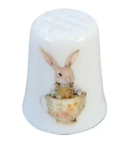 Foto de um(a) Dedal de Coleção em Porcelana – Coelhinhos e Xícara de Chá, da categoria de Outros colecionáveis. A decoração apresenta duas cenas distintas e encantadoras: de um lado, um coelhinho detalhado posando de pé; do outro, a... Vendido no marketplace Trésors.