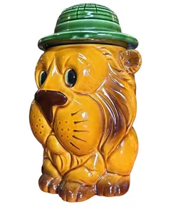 Foto de um(a) Potiche Antigo Leão de Cerâmica - Japan, da categoria de Garrafas, potes e jarros. Encantador potiche em cerâmica vitrificada, representando um leão com chapéu de explorador (safari). Esta peça é um exemplar... Vendido no marketplace Trésors.