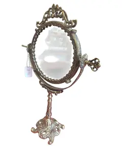 Foto de um(a) Espelho de Bancada em Bronze - Moldura Trabalhada com Fundo em Porcelana Floral, da categoria de Espelhos. Encantador espelho de bancada estilo vintage, uma peça decorativa clássica que une a robustez do bronze à delicadeza da... Vendido no marketplace Trésors.