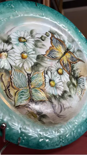 Foto de um(a) Prato de parede pintado à mão, da categoria de Pratos Decorativos. Prato de parede em porcelana, pintado à mão, assinado. Mostrado de uma perspectiva diferente. Vendido no marketplace Trésors.