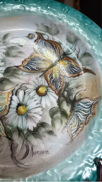 Foto de um(a) Prato de parede pintado à mão, da categoria de Pratos Decorativos. Prato de parede em porcelana, pintado à mão, assinado. Mostrado de uma perspectiva diferente. Vendido no marketplace Trésors.