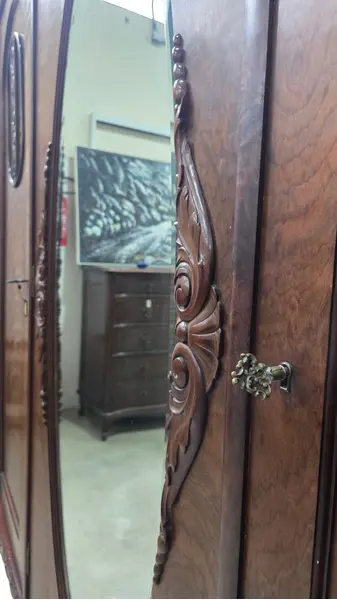 Foto de um(a) Guarda Roupa 3 Portas, Imbuia Maciça entalhado a mão, da categoria de Armários e Guarda Roupas. Guarda roupa 3 portas em imbuia maciça entalhado a mão, com espelho bisotê!. Mostrado de uma perspectiva diferente. Vendido no marketplace Trésors.