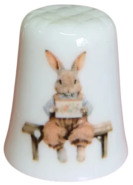 Foto de um(a) Dedal de Coleção em Porcelana - Estampa Casal de Coelhos e Coelhinho no Banco, da categoria de Outros colecionáveis. Este é um delicado dedal colecionável em porcelana branca, que apresenta uma temática lúdica e clássica de "Easter Bunnies"... Vendido no marketplace Trésors.