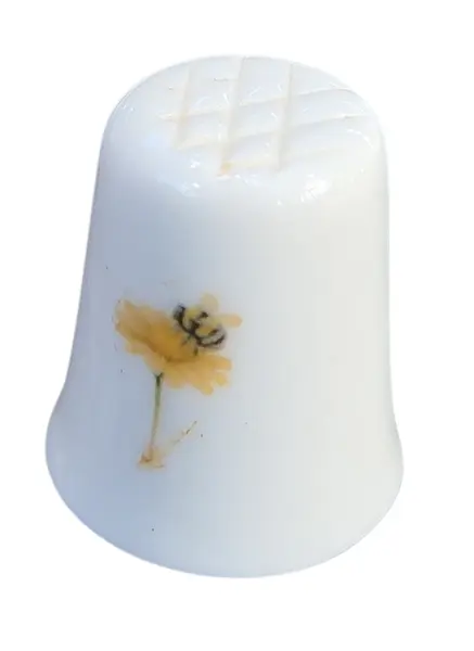 Foto de um(a) Dedal de Coleção em Porcelana – Tema Camomila e Abelha no Campo, da categoria de Outros colecionáveis. O design destaca-se pela composição harmoniosa: de um lado, um gracioso arranjo de camomilas (margaridas) brotando de uma... Mostrado de uma perspectiva diferente. Vendido no marketplace Trésors.