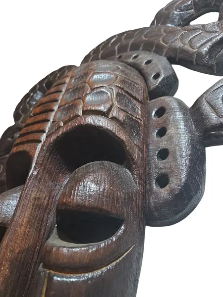 Foto de um(a) Máscara Tribal Decorativa em Madeira Nobre – Entalhe de Serpentes e Simbolismo Africano, da categoria de Objetos de parede esculturais. Esta é uma peça de arte mural imponente e sofisticada, perfeita para colecionadores ou para quem deseja um ponto focal... Mostrado de uma perspectiva diferente. Vendido no marketplace Trésors.