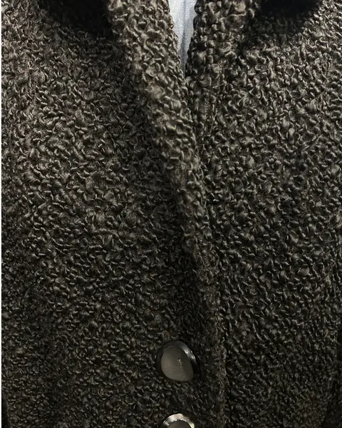 Foto de um(a) Casaco Vintage Bouclé Alongado Preto, da categoria de Casacos. Lindíssimo casaco vintage, tecido bouclé, bolsos frontais, 3 grandes botões para fechamento, grande gola, forrado, punhos... Mostrado de uma perspectiva diferente. Vendido no marketplace Trésors.