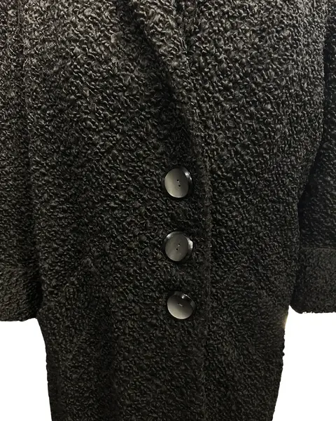 Foto de um(a) Casaco Vintage Bouclé Alongado Preto, da categoria de Casacos. Lindíssimo casaco vintage, tecido bouclé, bolsos frontais, 3 grandes botões para fechamento, grande gola, forrado, punhos... Mostrado de uma perspectiva diferente. Vendido no marketplace Trésors.