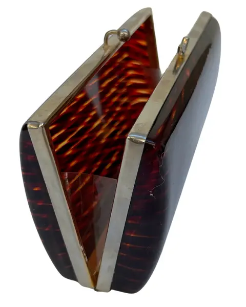 Foto de um(a) Clutch de Mão CGC Lucite Tartarura, da categoria de Bolsas. clutch vintage CGC, em lucite padrão tartaruga, ferragem em metal, fecho estilo vovó, não possui alça, compatível ao tamanho... Mostrado de uma perspectiva diferente. Vendido no marketplace Trésors.