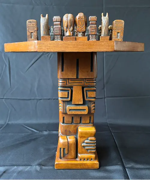 Foto de um(a) Mesa de Xadrez Entalhada, da categoria de Mesas de centro. Antiga mesa de xadrez, base em escultura de totem asteca entalhado em monobloco de carvalho, tampo oitavado com inscrições... Mostrado de uma perspectiva diferente. Vendido no marketplace Trésors.
