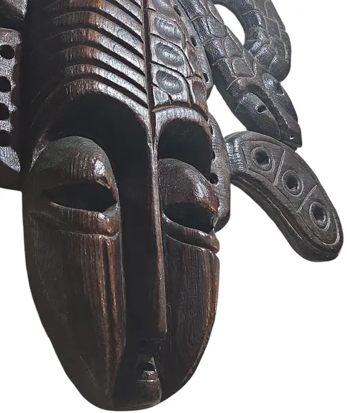 Foto de um(a) Máscara Tribal Decorativa em Madeira Nobre – Entalhe de Serpentes e Simbolismo Africano, da categoria de Objetos de parede esculturais. Esta é uma peça de arte mural imponente e sofisticada, perfeita para colecionadores ou para quem deseja um ponto focal... Mostrado de uma perspectiva diferente. Vendido no marketplace Trésors.