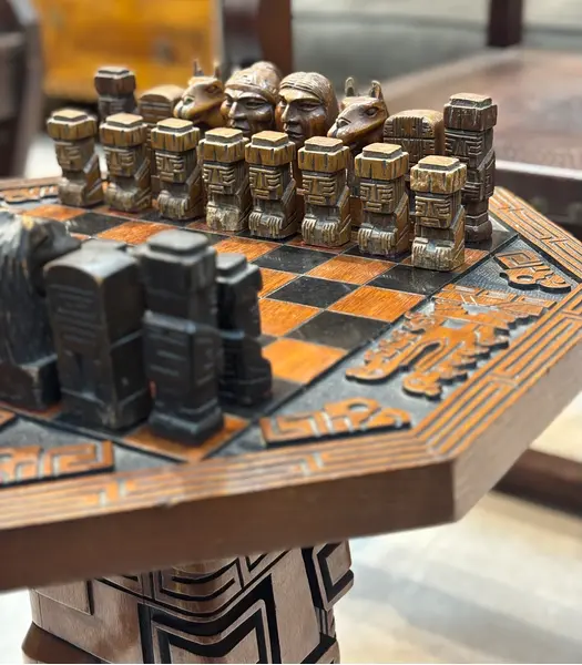 Foto de um(a) Mesa de Xadrez Entalhada, da categoria de Mesas de centro. Antiga mesa de xadrez, base em escultura de totem asteca entalhado em monobloco de carvalho, tampo oitavado com inscrições... Mostrado de uma perspectiva diferente. Vendido no marketplace Trésors.