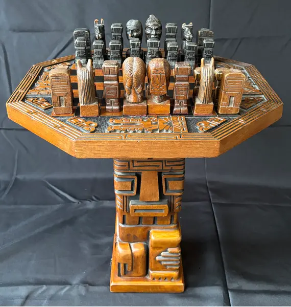 Foto de um(a) Mesa de Xadrez Entalhada, da categoria de Mesas de centro. Antiga mesa de xadrez, base em escultura de totem asteca entalhado em monobloco de carvalho, tampo oitavado com inscrições... Mostrado de uma perspectiva diferente. Vendido no marketplace Trésors.