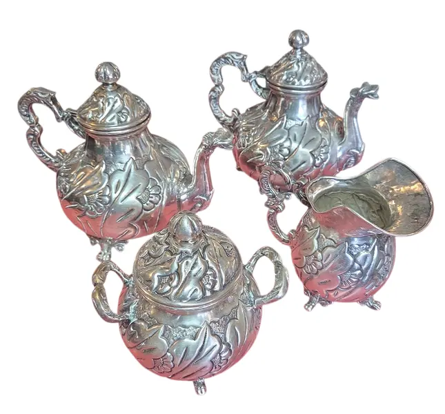 Foto de um(a) Aparelho de Chá e Café Colonial em Prata – 5 Peças Trabalhadas, da categoria de Conjuntos de café e chá. Magnífico conjunto colonial para chá e café, composto por 5 peças ricamente adornadas. Este aparelho é um exemplo clássico... Mostrado de uma perspectiva diferente. Vendido no marketplace Trésors.