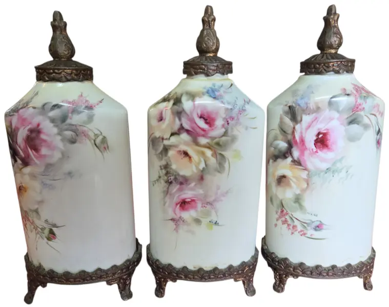 Foto de um(a) Trio de Potes em Porcelana Pintada à Mão com Base e Tampa em Bronze - Estilo Floral Clássico, da categoria de Garrafas, potes e jarros. Apresentamos este magnífico trio de potiches (vasos com tampa) em porcelana de alta qualidade, apresentando um formato... Mostrado de uma perspectiva diferente. Vendido no marketplace Trésors.