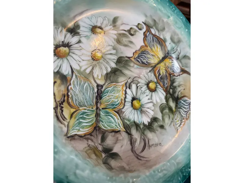Foto de um(a) Prato de parede pintado à mão, da categoria de Pratos Decorativos. Prato de parede em porcelana, pintado à mão, assinado. Mostrado de uma perspectiva diferente. Vendido no marketplace Trésors.