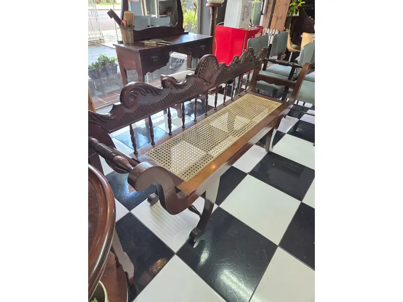 Foto de um(a) Banco colonial em Imbuia maciça entalhada com assento em palhinha, da categoria de Recamier e Chaise. Banco antigo confeccionado em imbuia maciça entalhada à mão, apresentando rico trabalho artesanal no encosto e nos braços... Mostrado de uma perspectiva diferente. Vendido no marketplace Trésors.