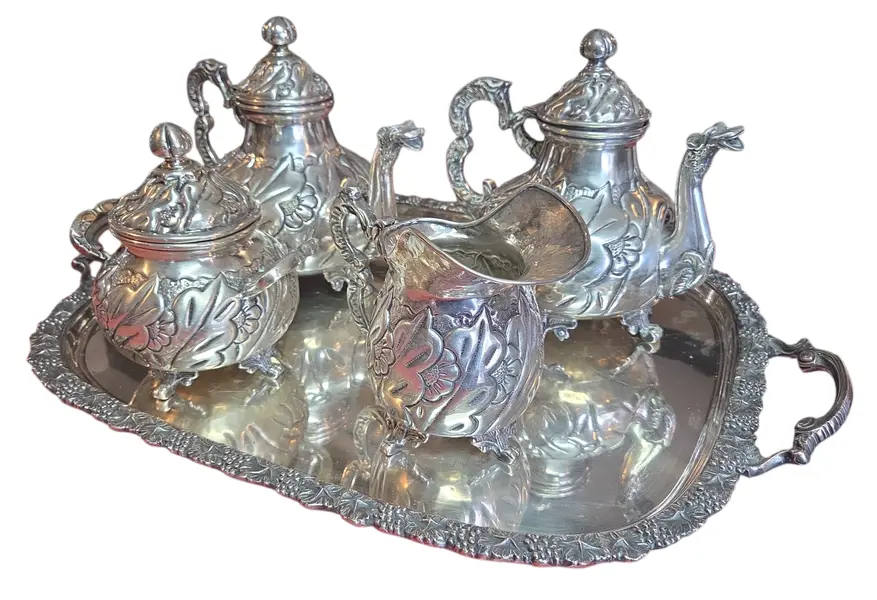 Foto de um(a) Aparelho de Chá e Café Colonial em Prata – 5 Peças Trabalhadas, da categoria de Conjuntos de café e chá. Magnífico conjunto colonial para chá e café, composto por 5 peças ricamente adornadas. Este aparelho é um exemplo clássico... Mostrado de uma perspectiva diferente. Vendido no marketplace Trésors.